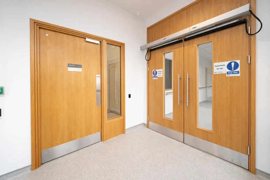 interior secured wood double doors with electric strike access control system for restricted building entry areas